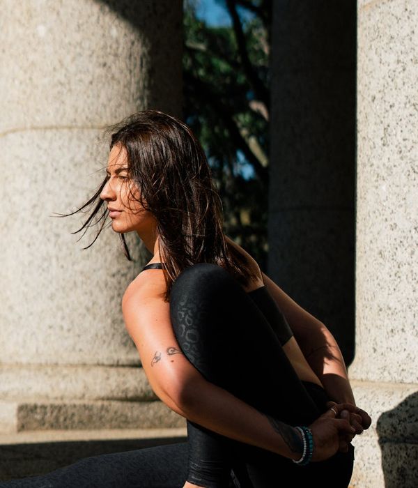 Woman in a serene morning yoga pose against a dark background with mint accents.